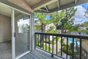 Exterior Unit Balcony, view of pool area and lush foliage, sliding glass door to living room.